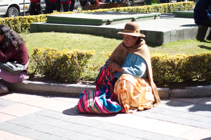 A Cholita sitting in La Plaza Alvaroa.