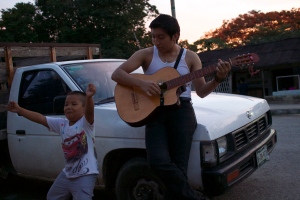 My cousin Gibran plays guitar in front of the family truck as the sun goes down, and my nephew Ronaldo dances. 