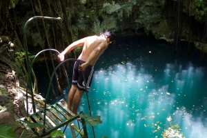 Josué looks down into cenote Yaxuna before descending the tall ladder. 